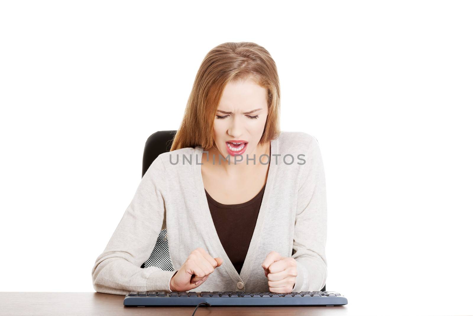 Beautiful casual woman writing on keyboard with anger. by BDS