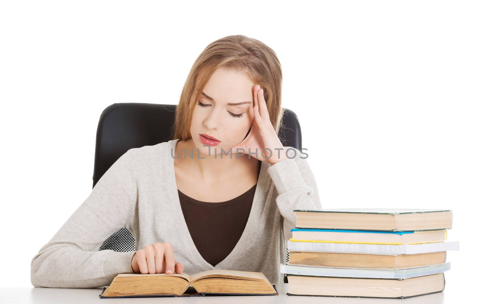 Beautiful casual student woman sitting by stack of books and lea by BDS