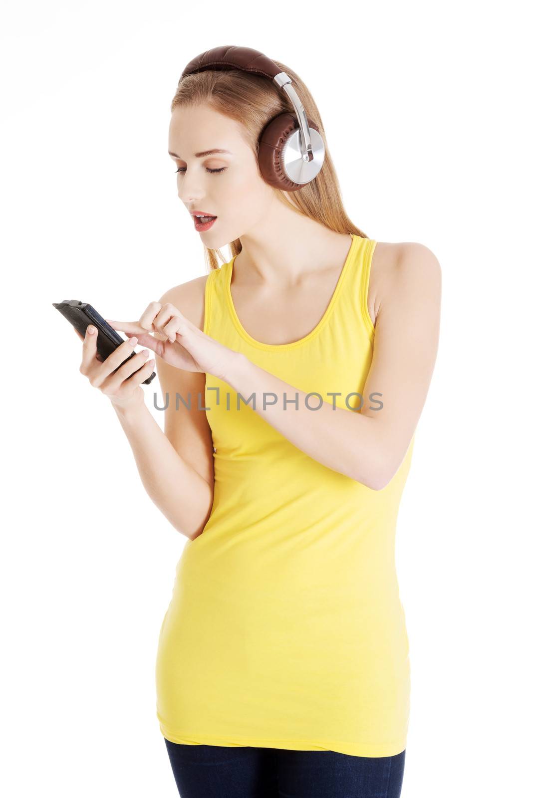 Young beautiful woman listening to music with headphones. Isolated on white.
