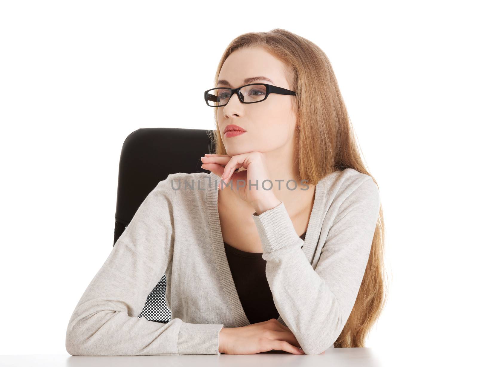 Portrait of beautiful thoughtful woman in eyeglasses sitting. Isolated on white.