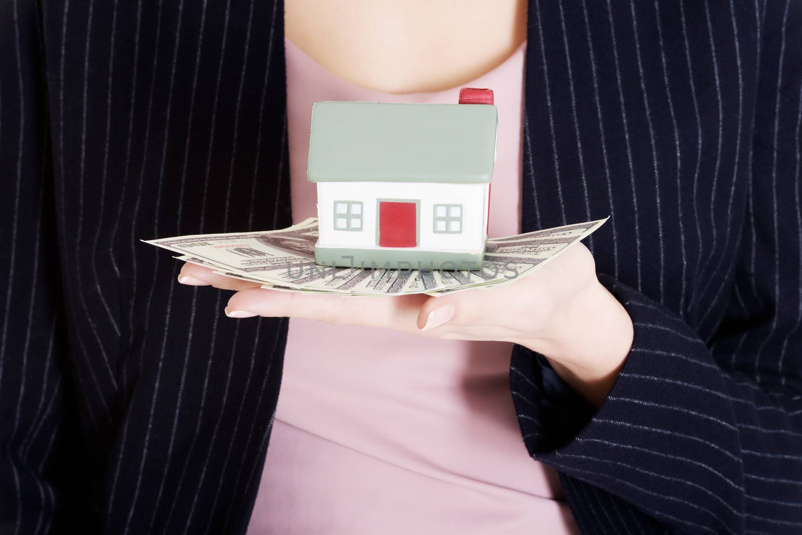 Beautiful business woman holding dollar currency and house. Close up.
