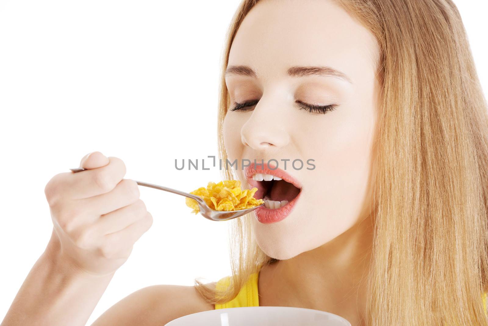 Beautiful caucasian woman eating cereals. Isolated on white.