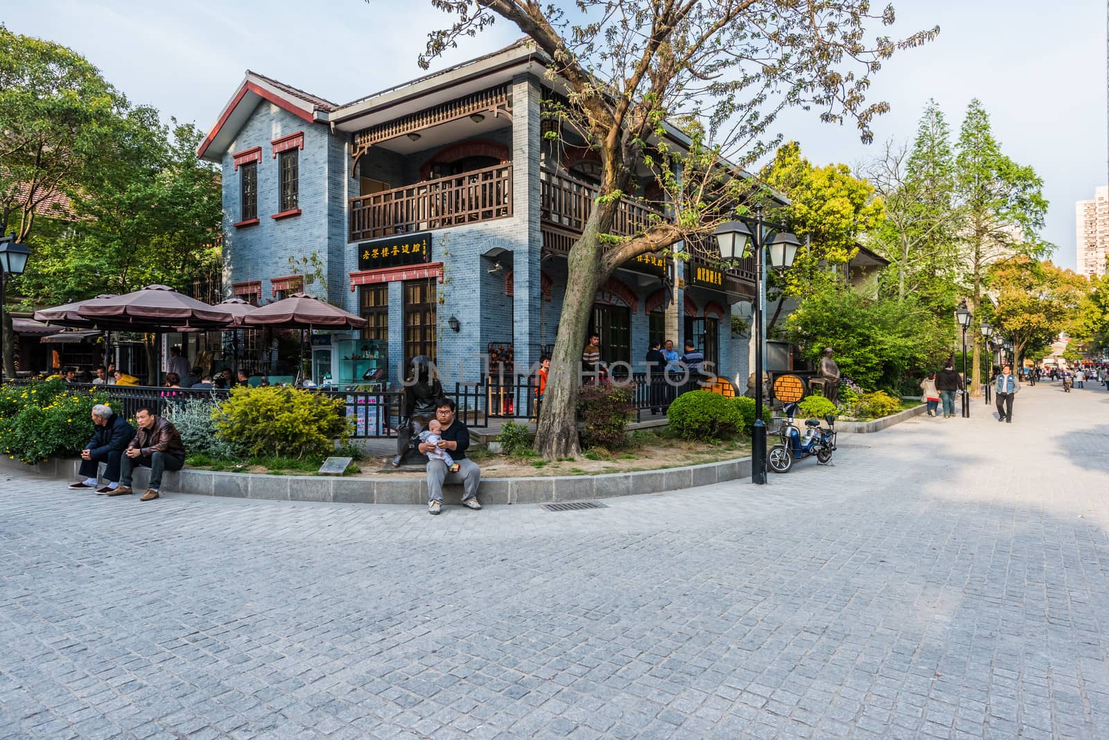 Shanghai, China - April 7, 2013: people sitting along the pedestrian way of duolon road at the city of Shanghai in China on april 7th, 2013