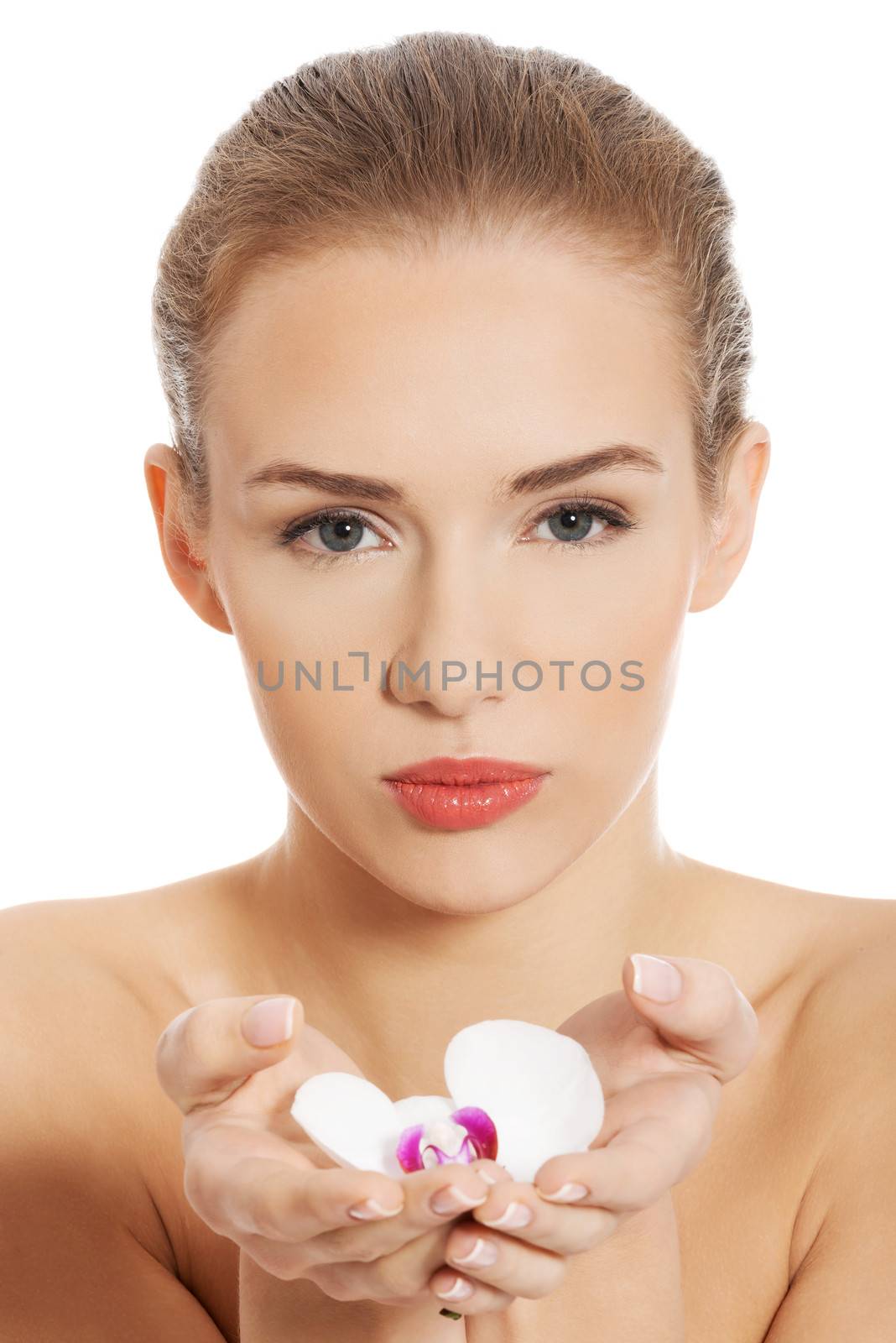 Beautiful naked woman holding white flower on hands. Isolated on white.