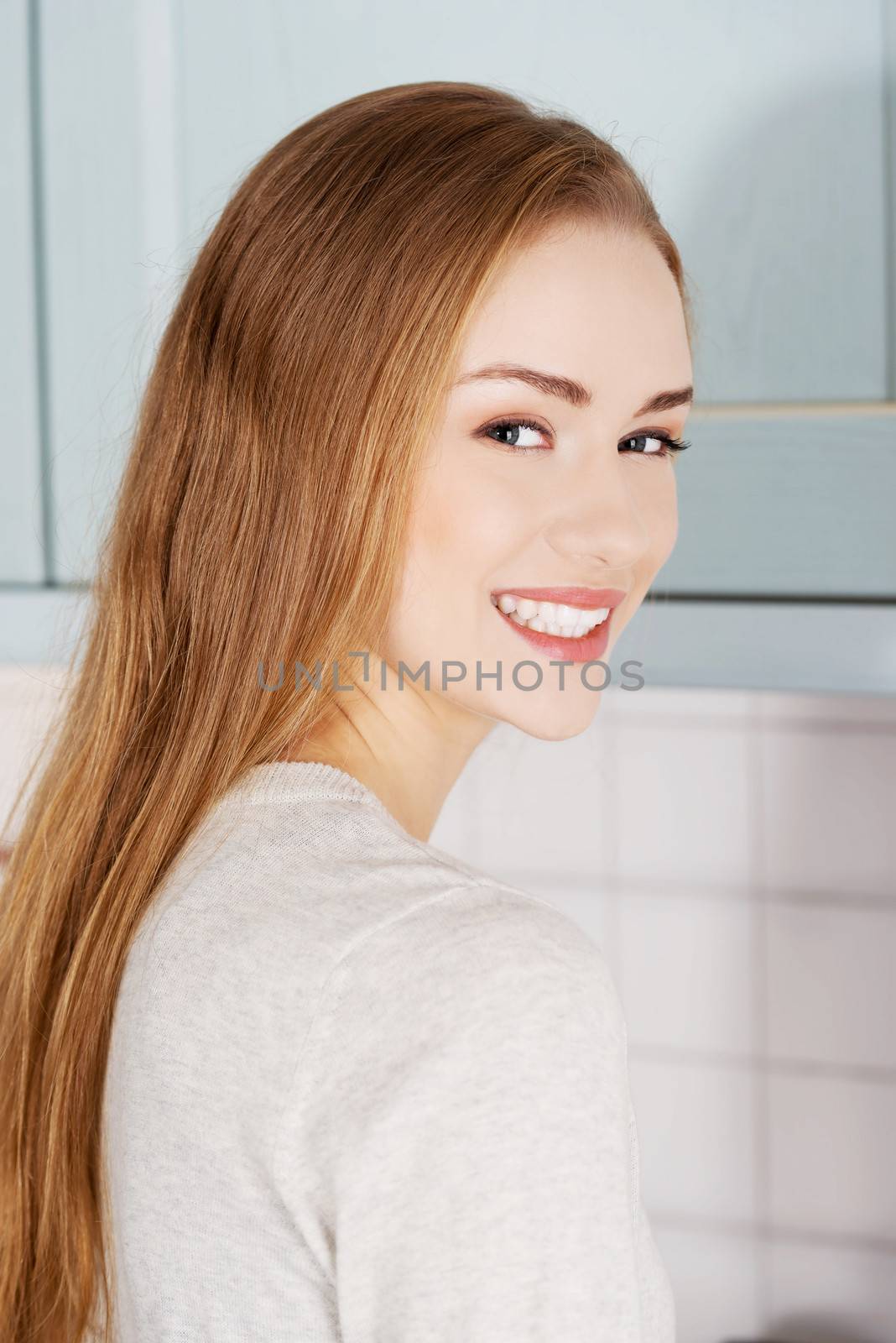 Portraif of beautiful caucasian woman standing in the kitchen.