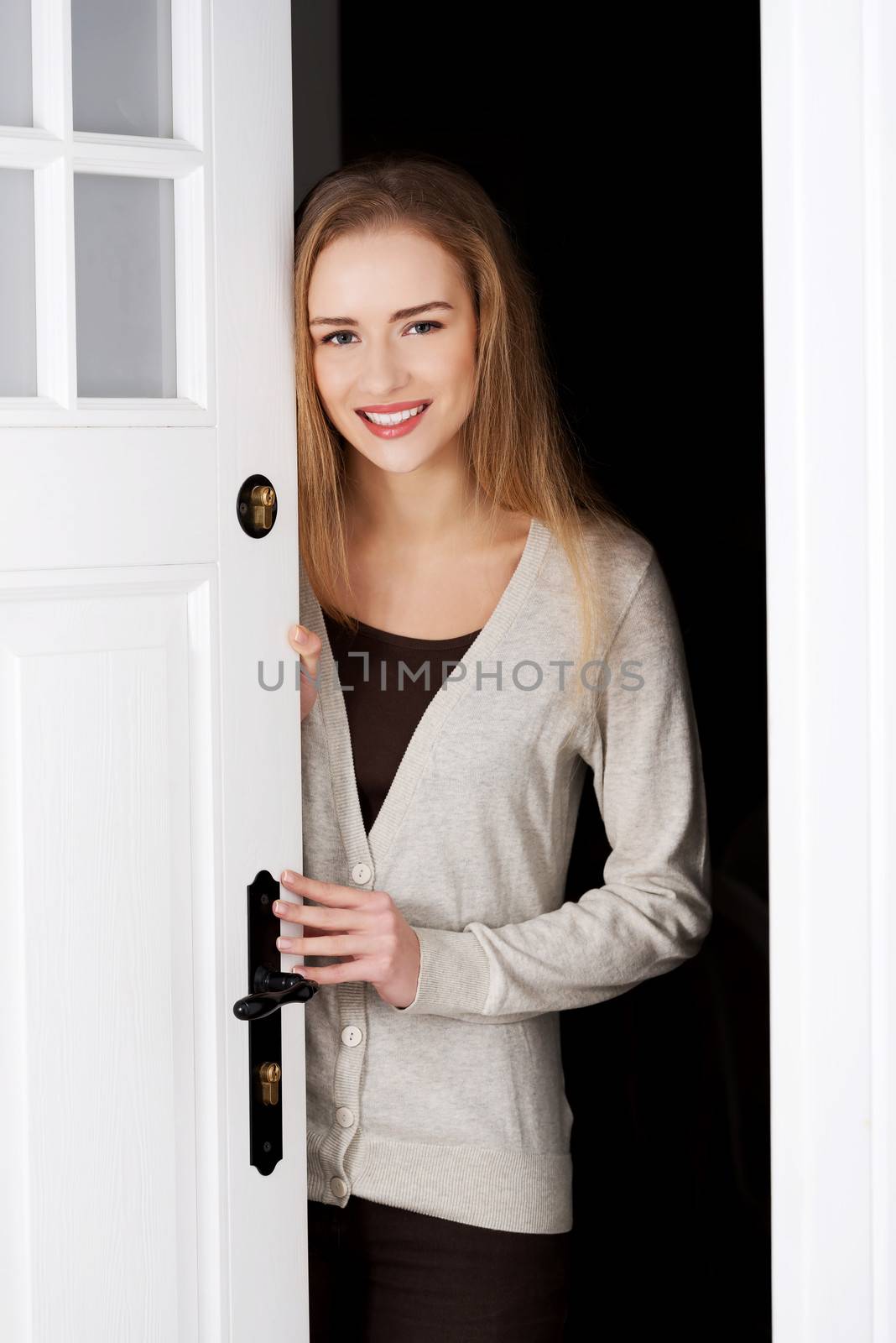 Beautiful caucasian woman standing by the door and opening them.