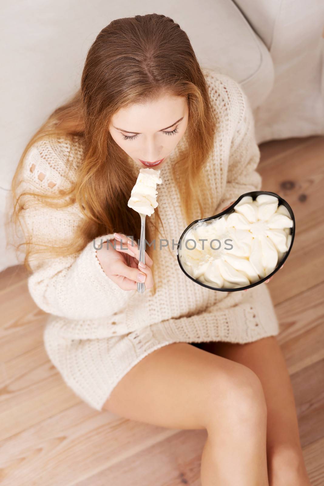 Young depressed woman is eating big bowl of ice creams to comfort herself. Depression, bulimia and diet concept.