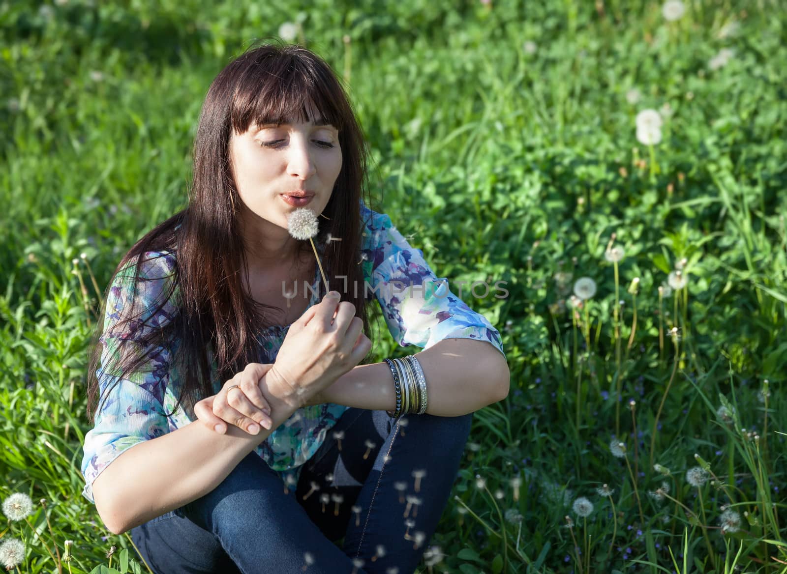 Young beautiful woman resting on fresh green grass