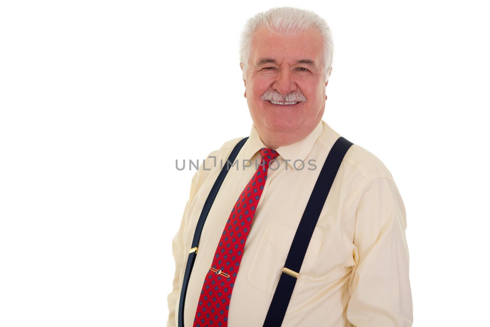 Happy senior man with a moustache wearing braces and a red tie looking at the camera with a charming beaming smile isolated on white