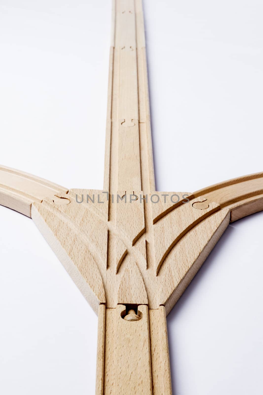 forked wooden railroad track on grey background. vertical image with depth of field