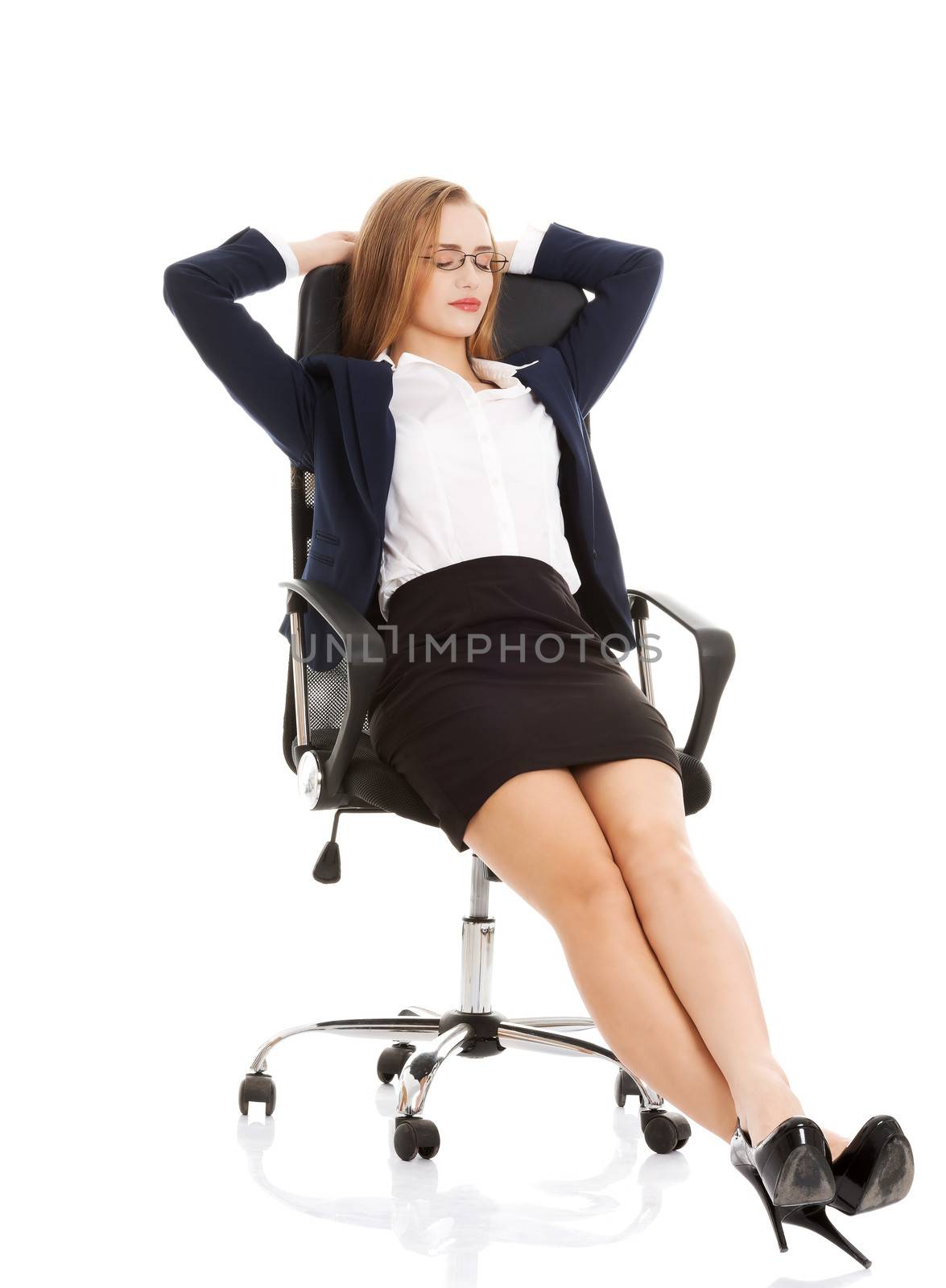 Relaxed business woman sitting on a chair with closed eyes. Isolated on white.