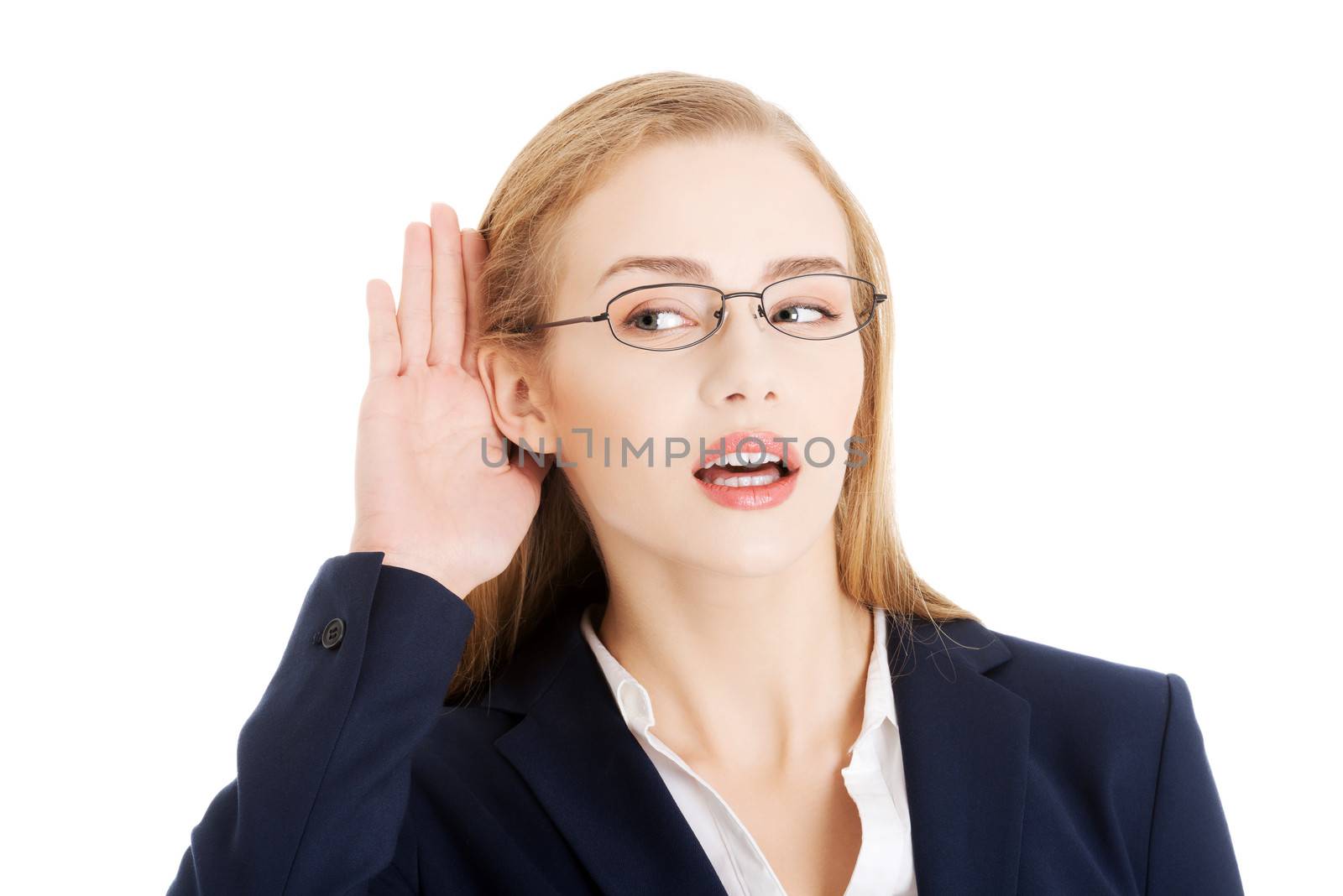 Beautiful business woman is over- hearing, trouching her ear. Isolated on white.