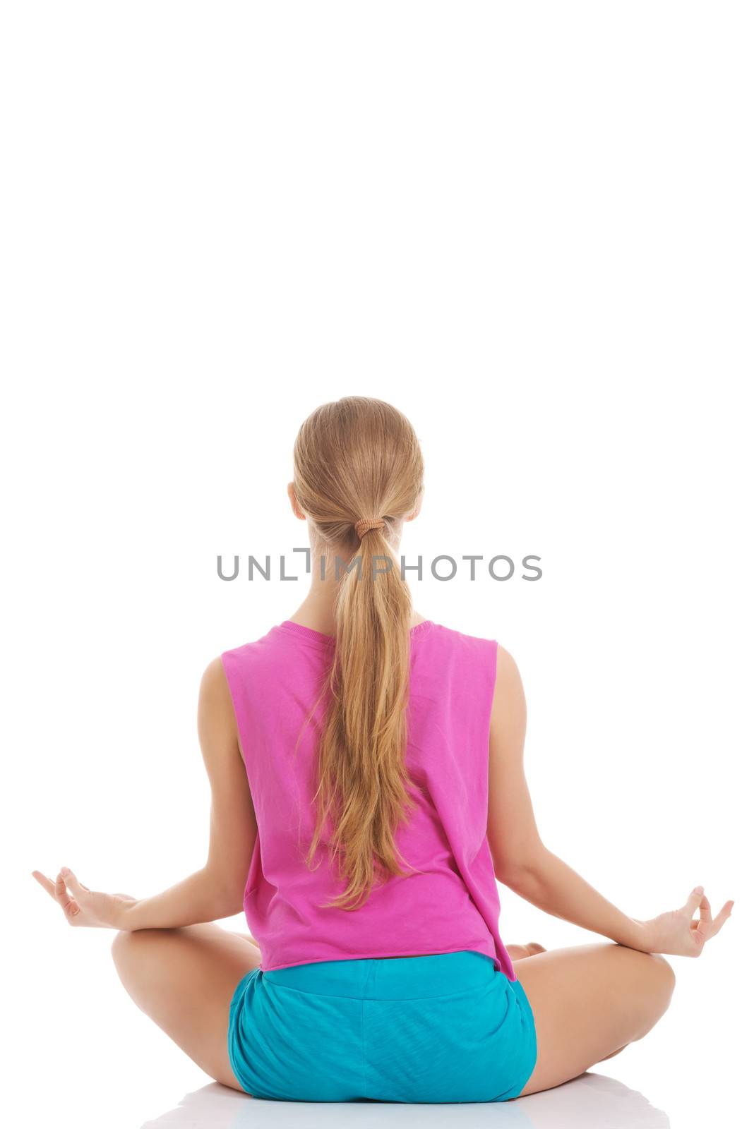 Beautiful young caucasian woman is exercising, doing yoga. by BDS