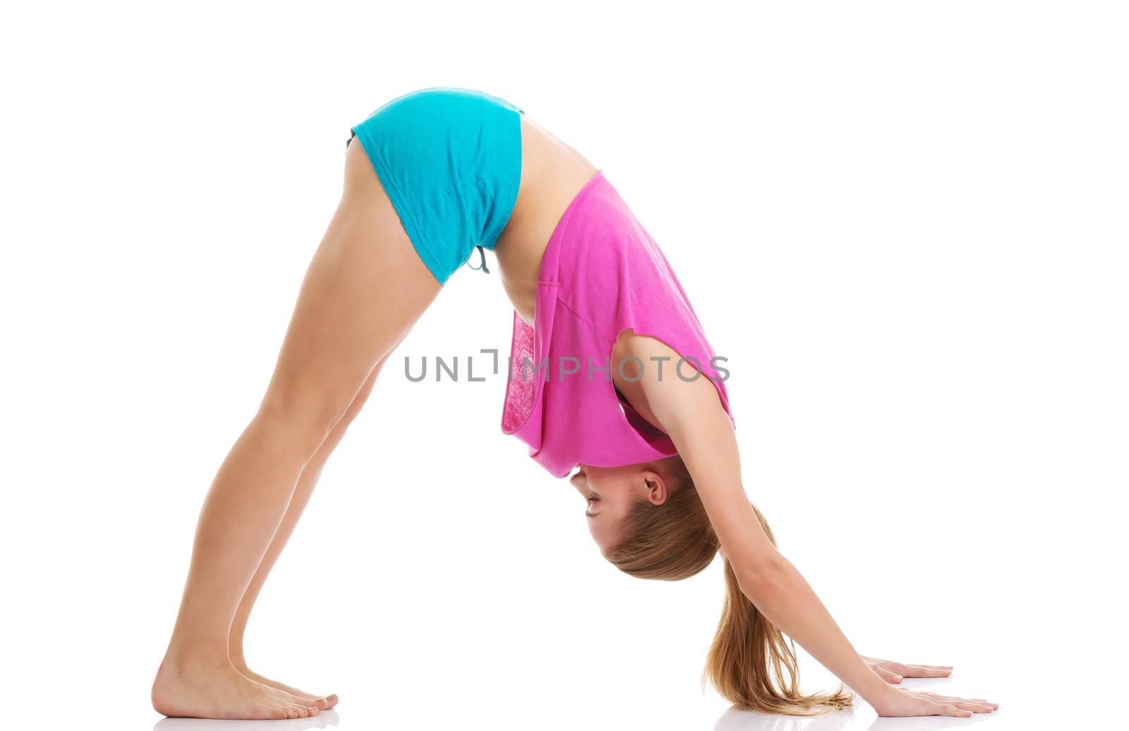 Young caucasian woman is exercising, bending down. Isolated on white.