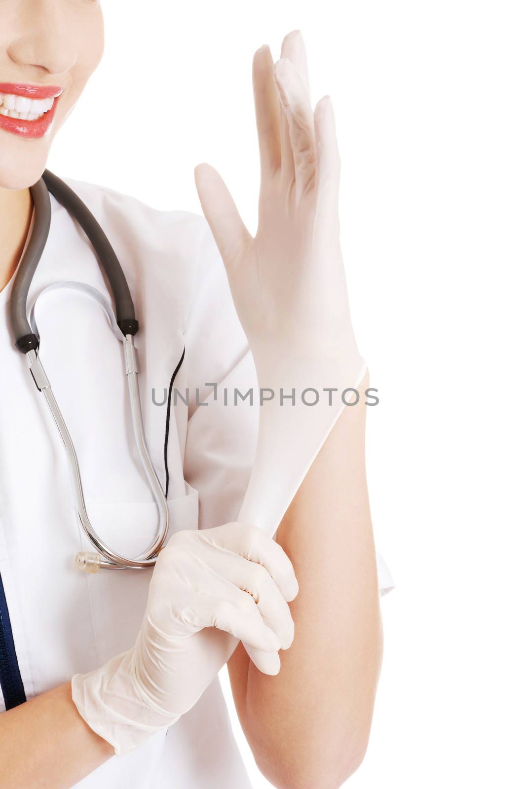 Beautiful young doctor or nurse putting sterile gloves. Isolated on white.