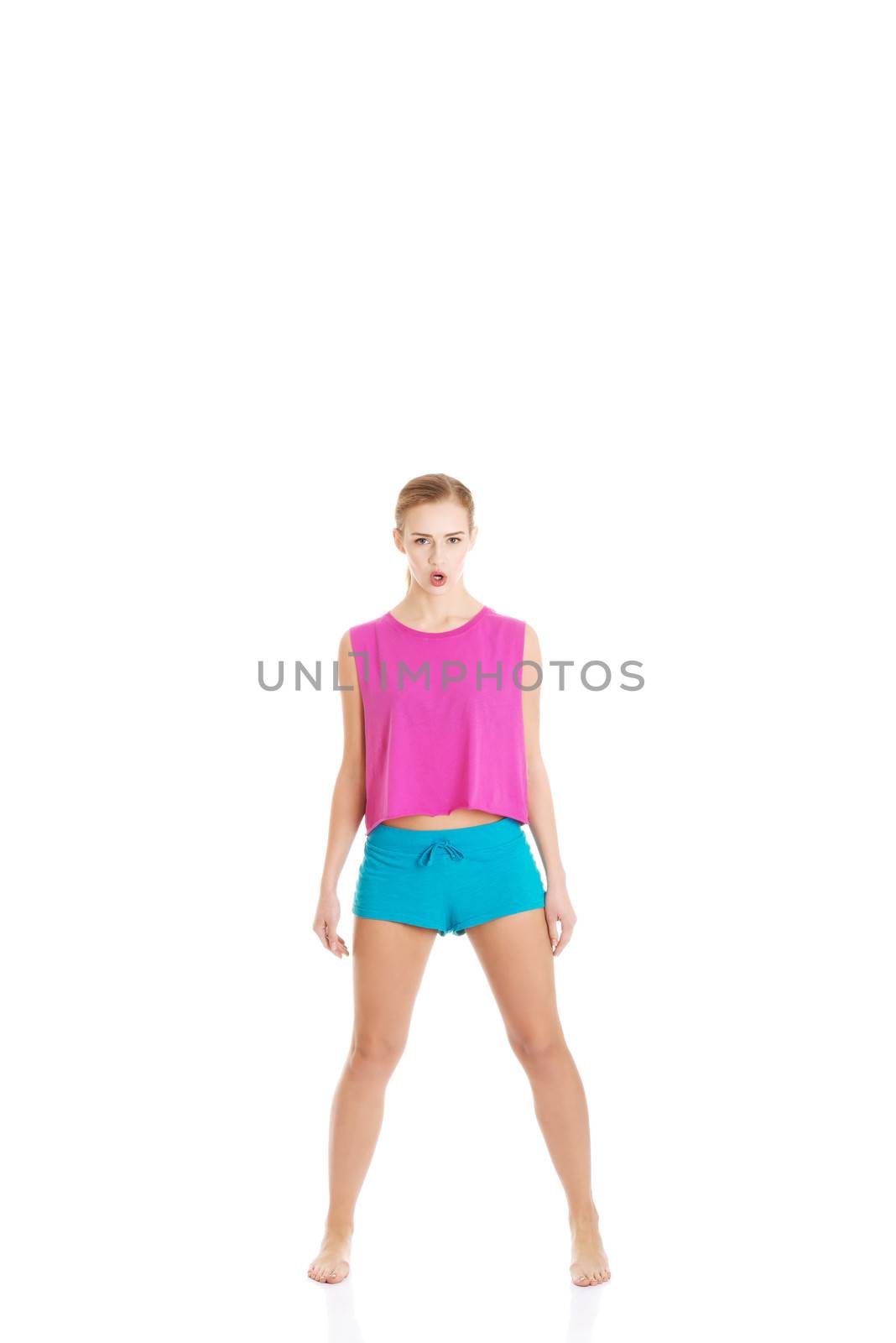 Young caucasian woman is doing exercises, wearing sportswear. Isolated on white.