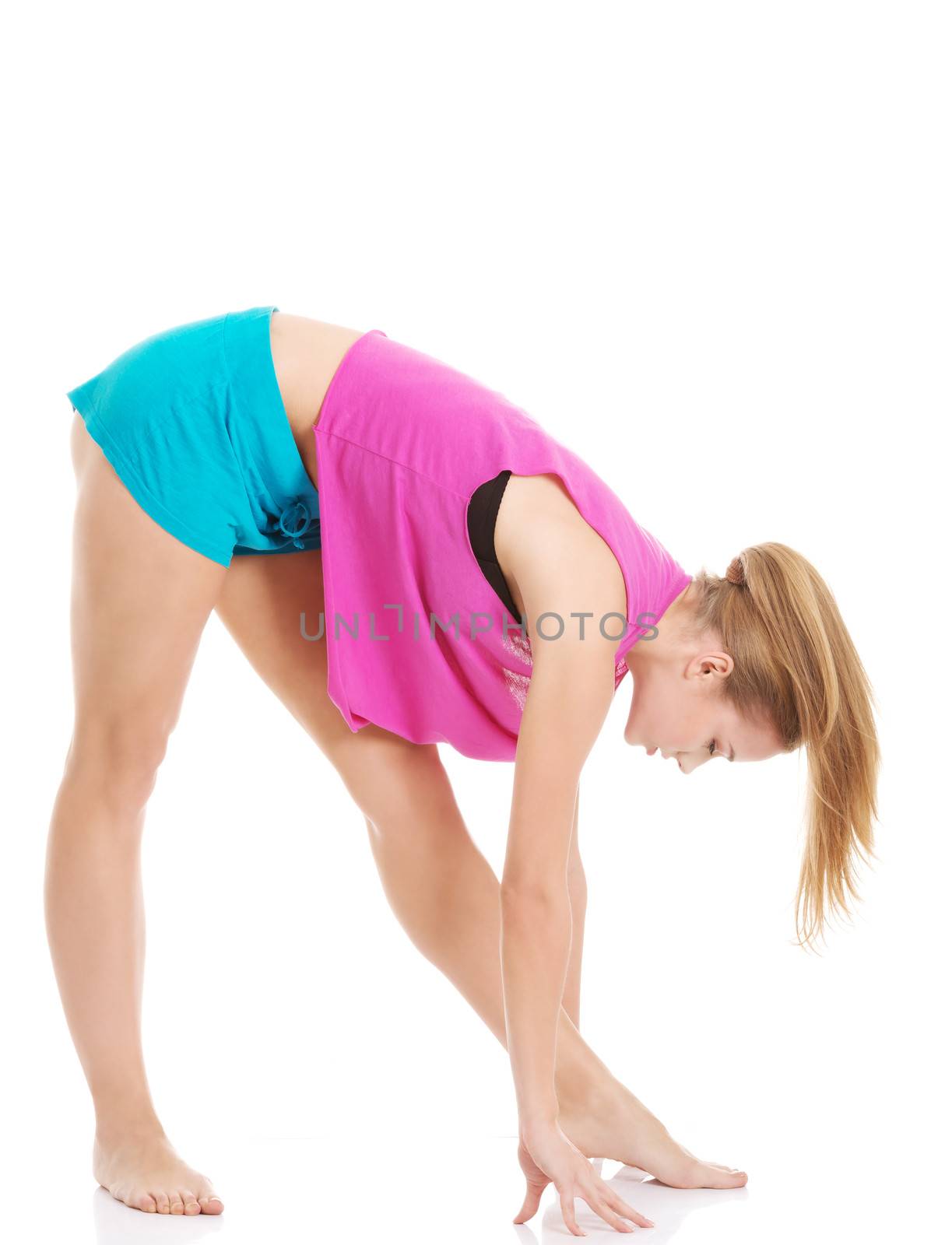Young caucasian woman is exercising, bending down. Isolated on white.
