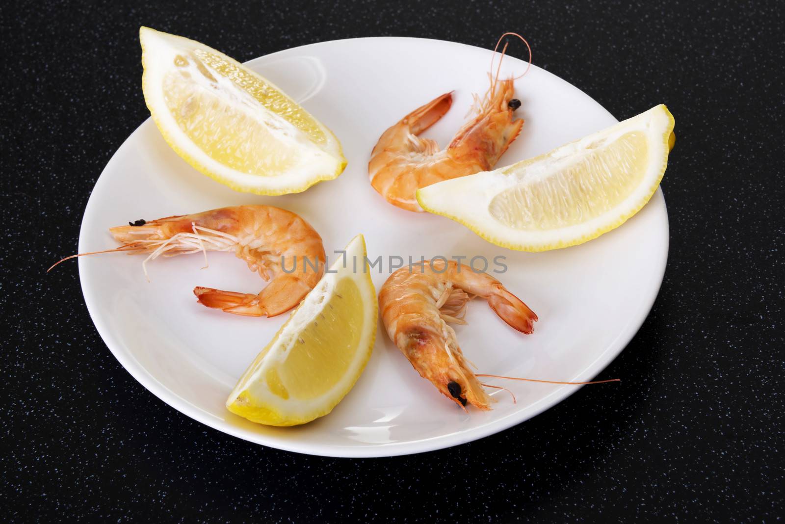 Fresh shrimps with lemon. On a kitchen table.