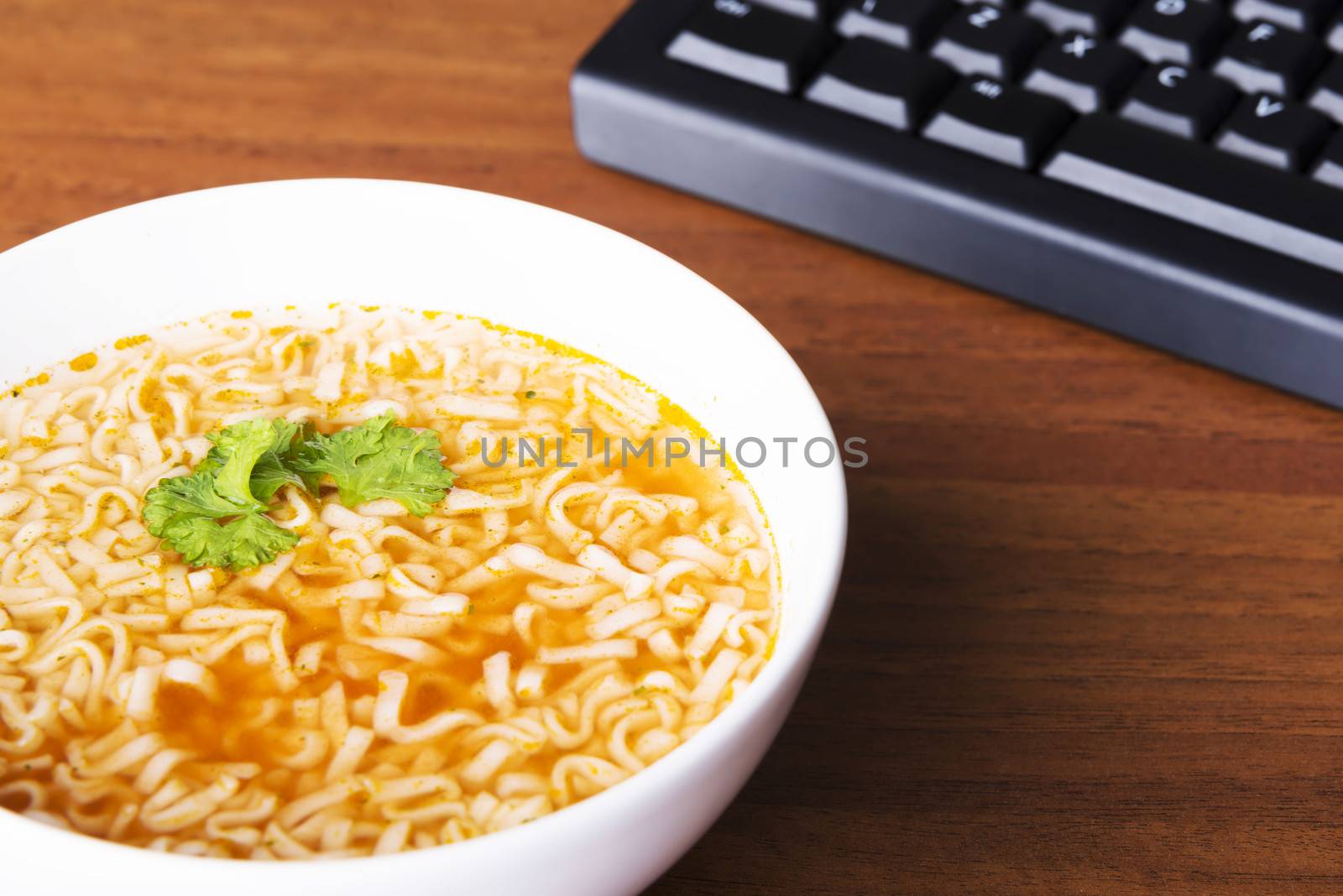 Chinese, vegetable, pasta soup next to keyboard. by BDS