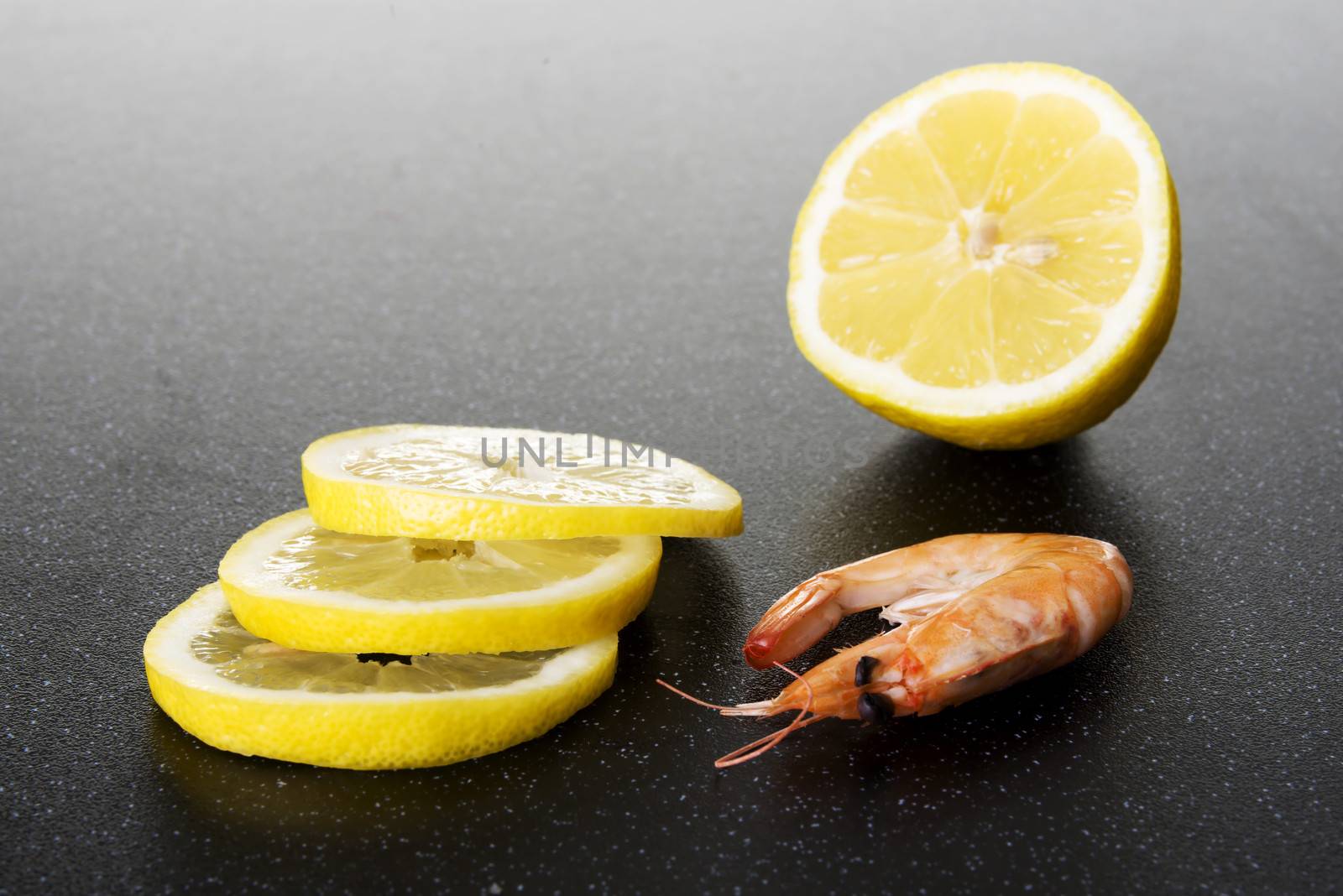 Fresh shrimps with lemon. On a kitchen table.