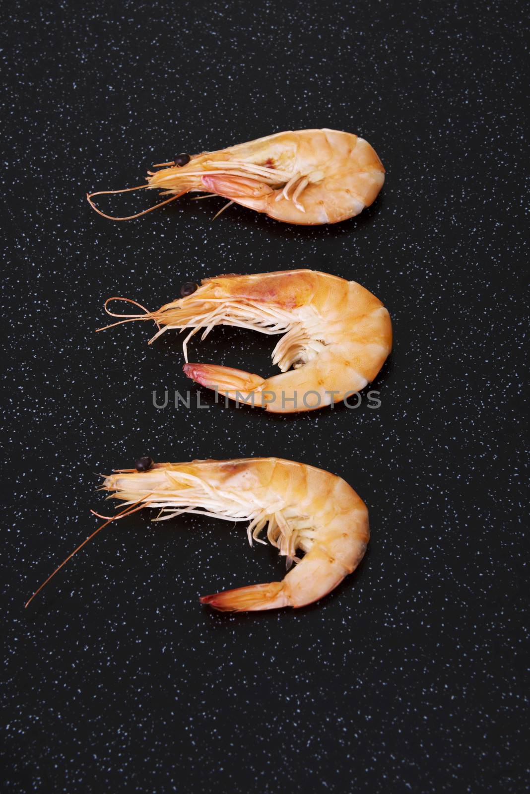Three separated shrimps lying on a kitchen table. by BDS