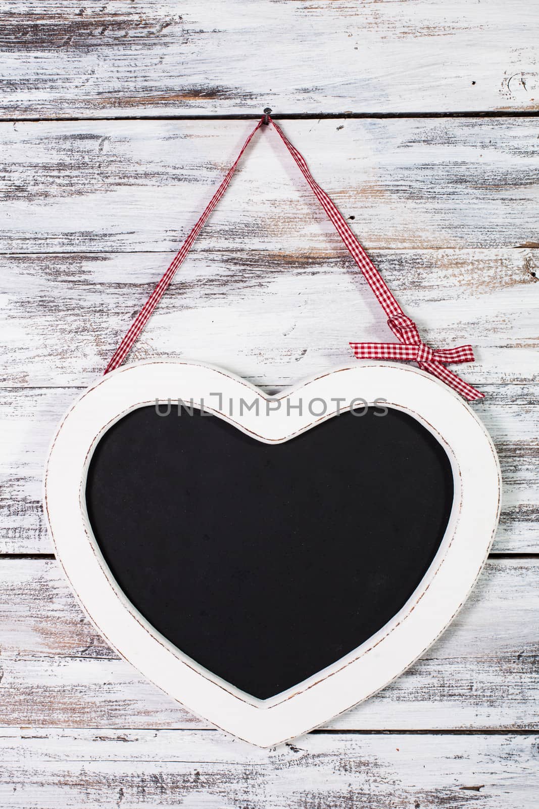 The heart shape chalkboard over shabby wooden background
