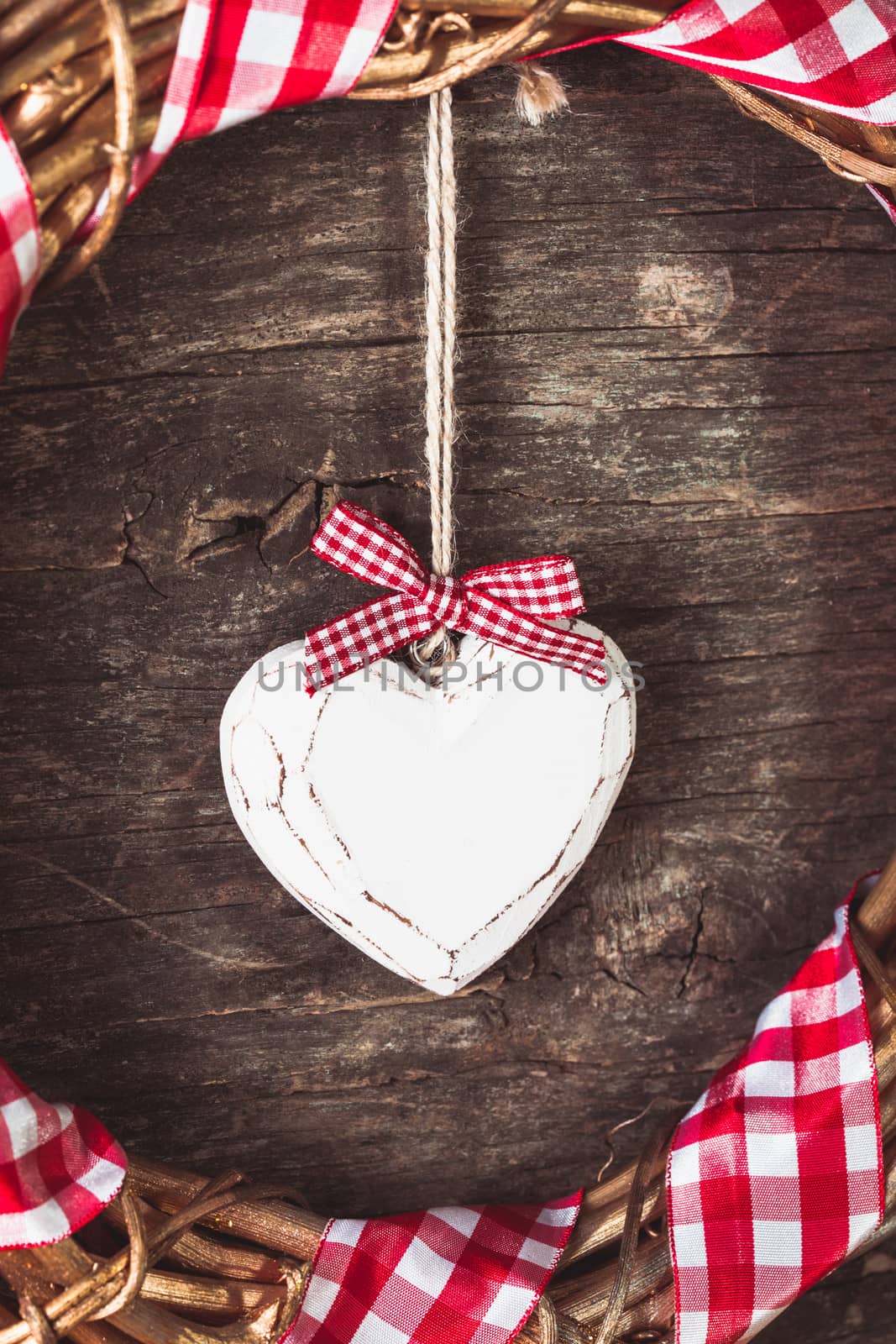 White heart and wreath over wooden old background