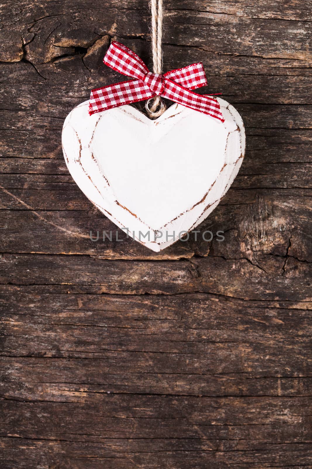 White carved heart over old wooden background, valentine decor