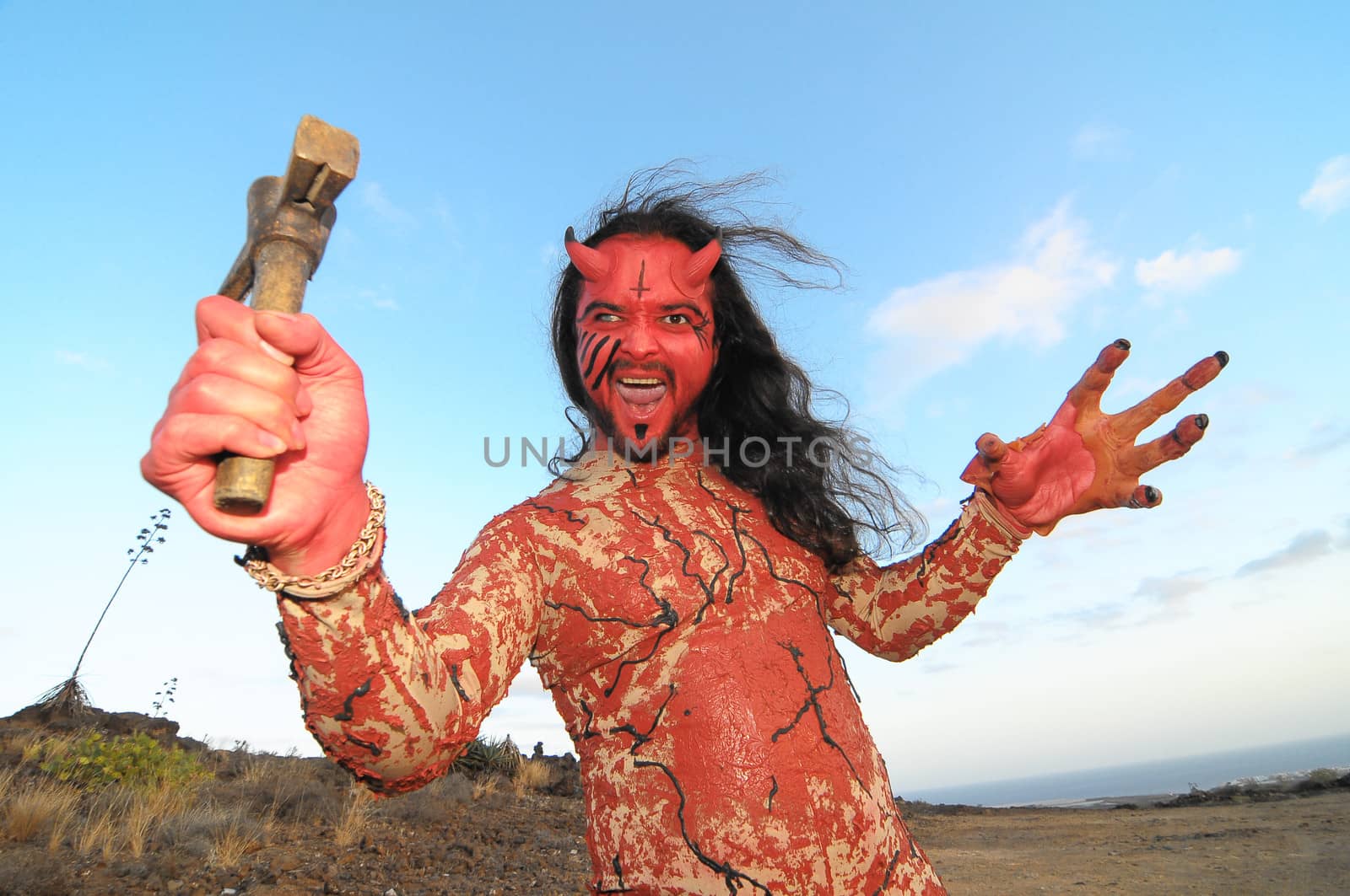 Latin American Man with Long Hairs Masked as a Devil in the Desert