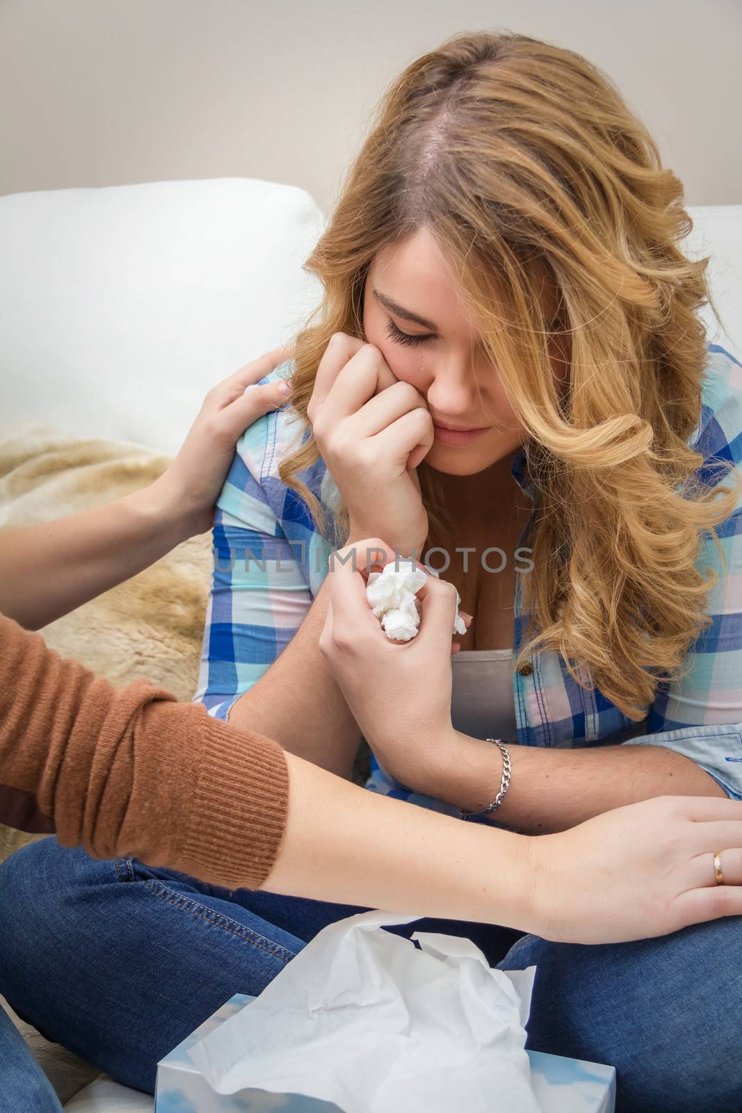 Hands of mother closeup consoling sad teen daughter crying by problems