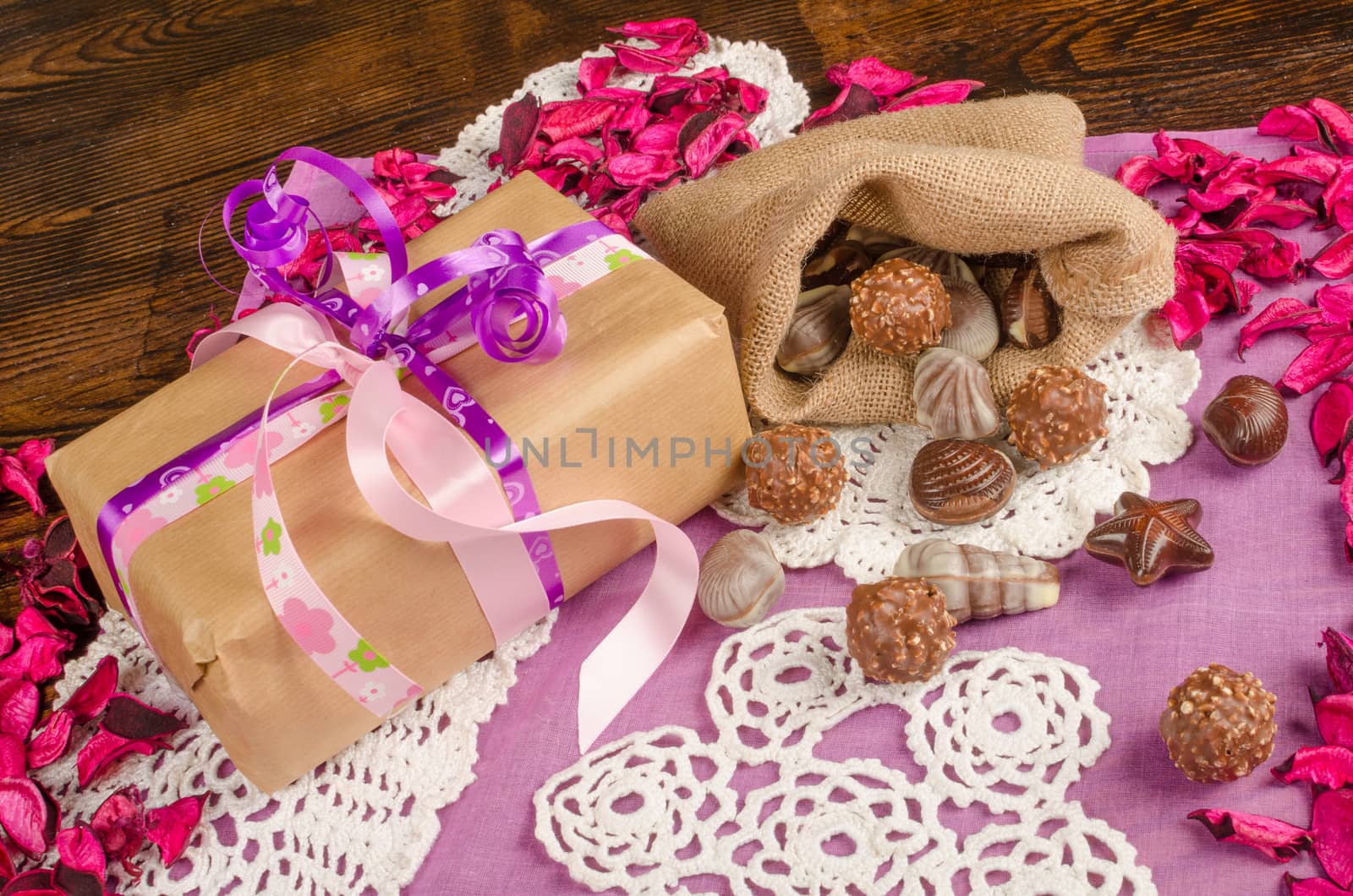 Valentines gift in a still life with flower petals and treats