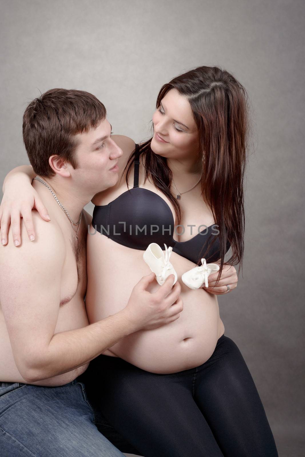 pregnant woman with a child's shoe, couple in love