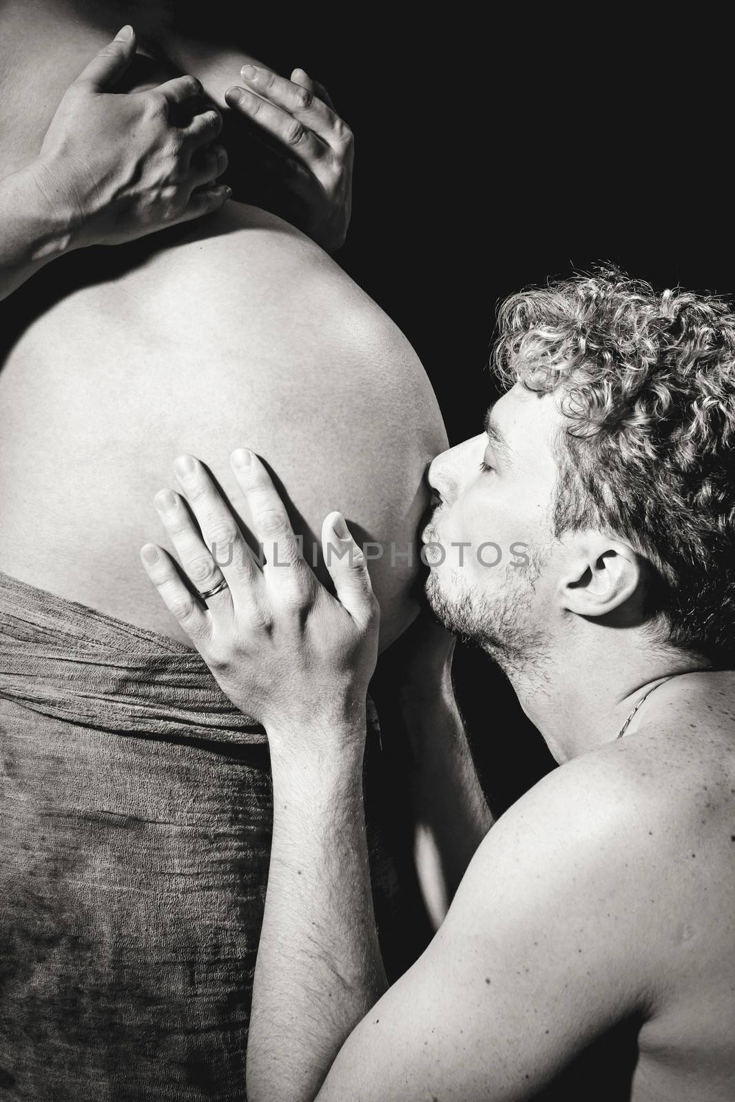 loving happy couple, pregnant woman with her husband, man husband kissing tummy