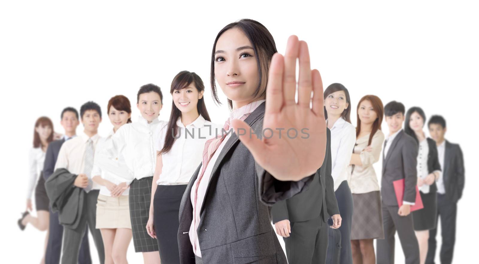 Attractive Asian business woman give you a stop sign and stand in front of her team.