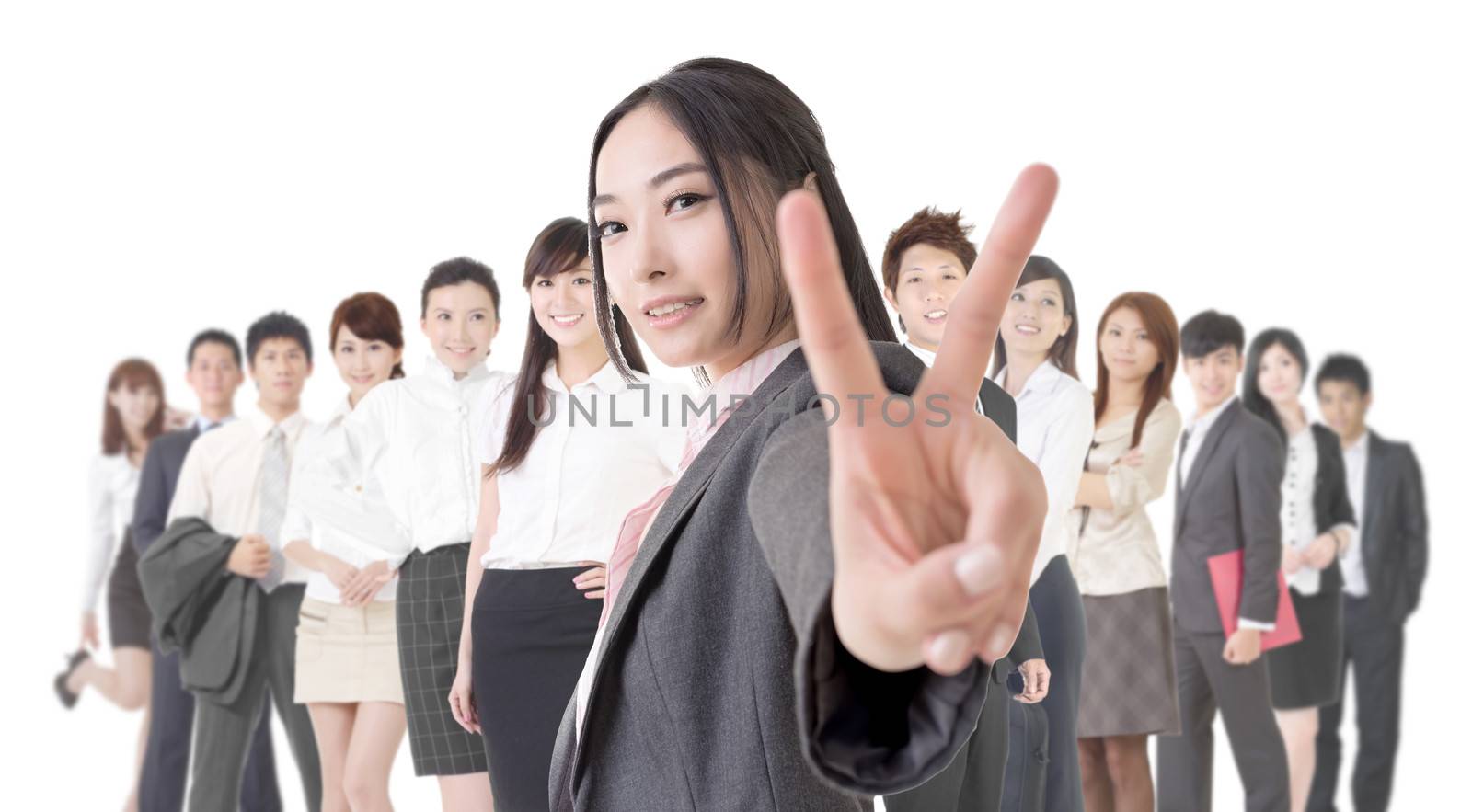 Attractive Asian business woman give you a victory sign and stand in front of her team.