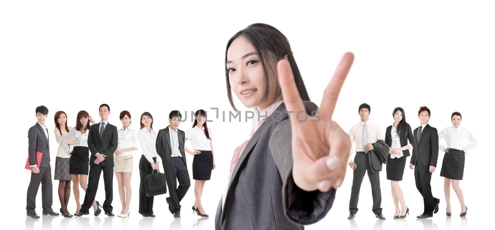 Attractive Asian business woman give you a victory sign and stand in front of her team.