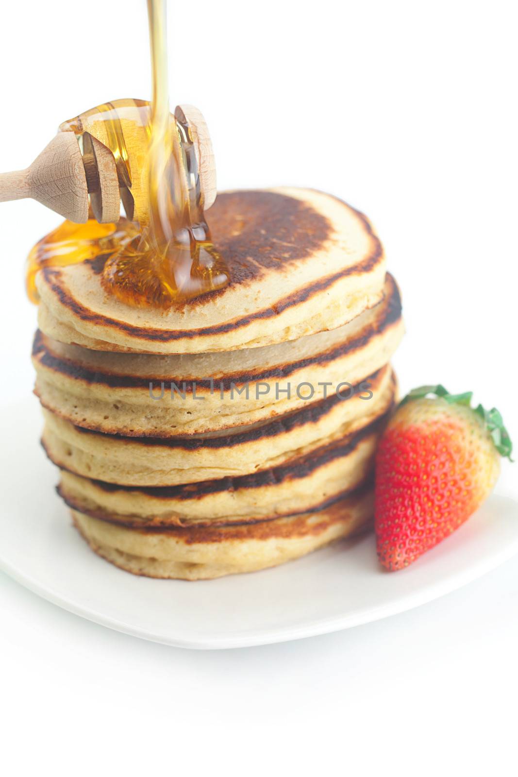 Pancakes, honey, strawberry and stick to honey isolated on white by jannyjus