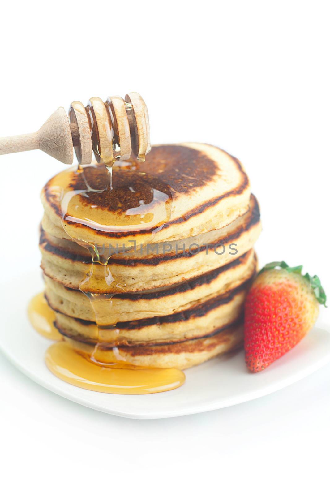 Pancakes, honey, strawberry and stick to honey isolated on white by jannyjus