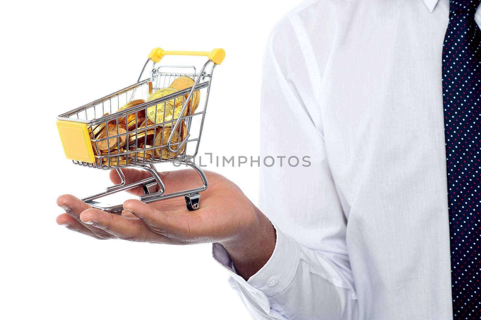 Man holding a shopping cart filled with gold coins by stockyimages