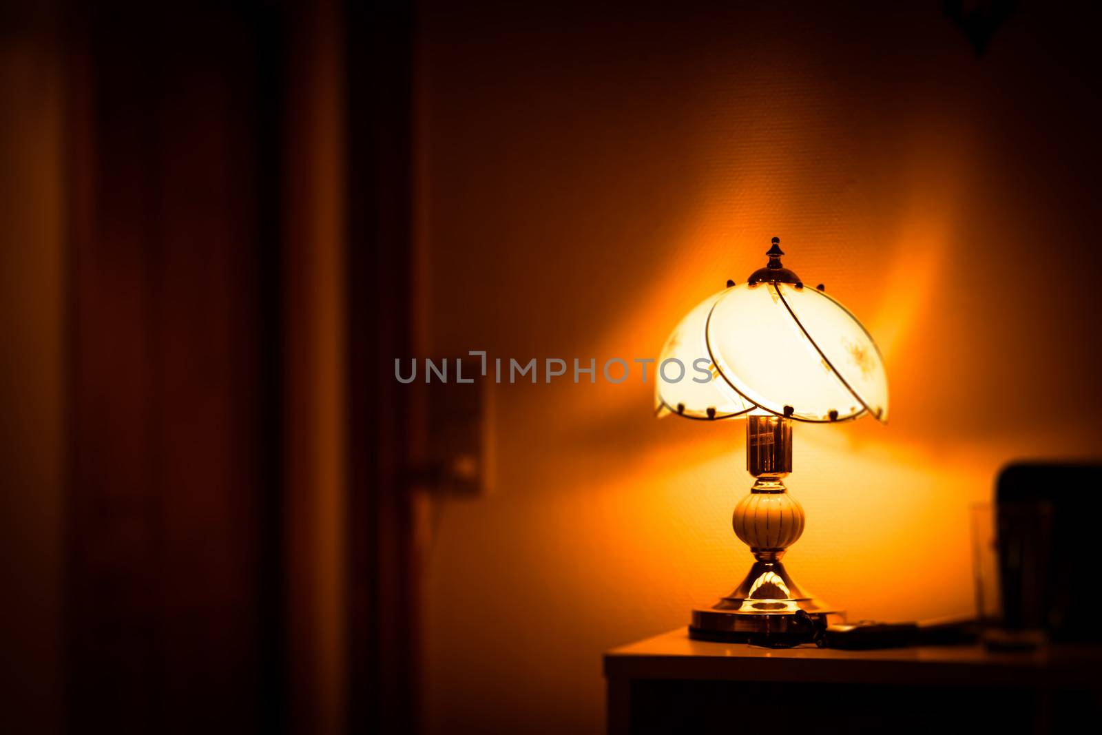 Old fashioned antique lamp glowing on a table