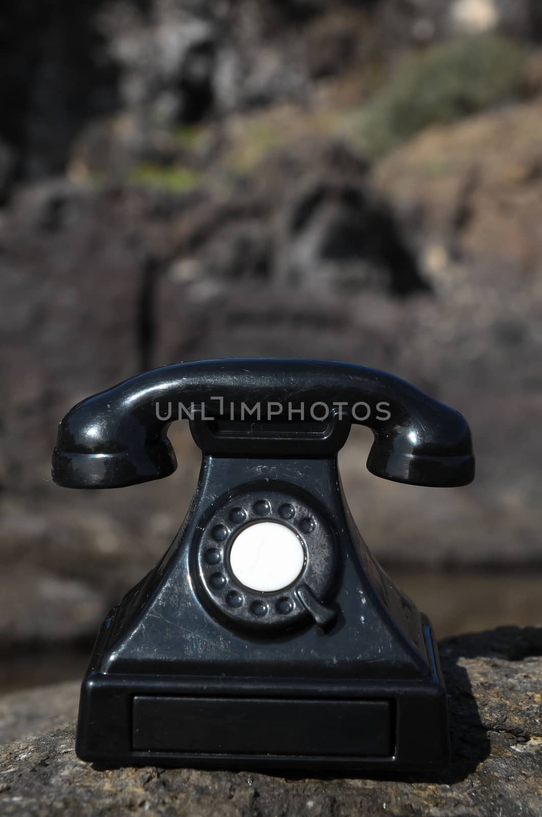 International Communications Vintage Telephone Toy on the Volcanic Rocks