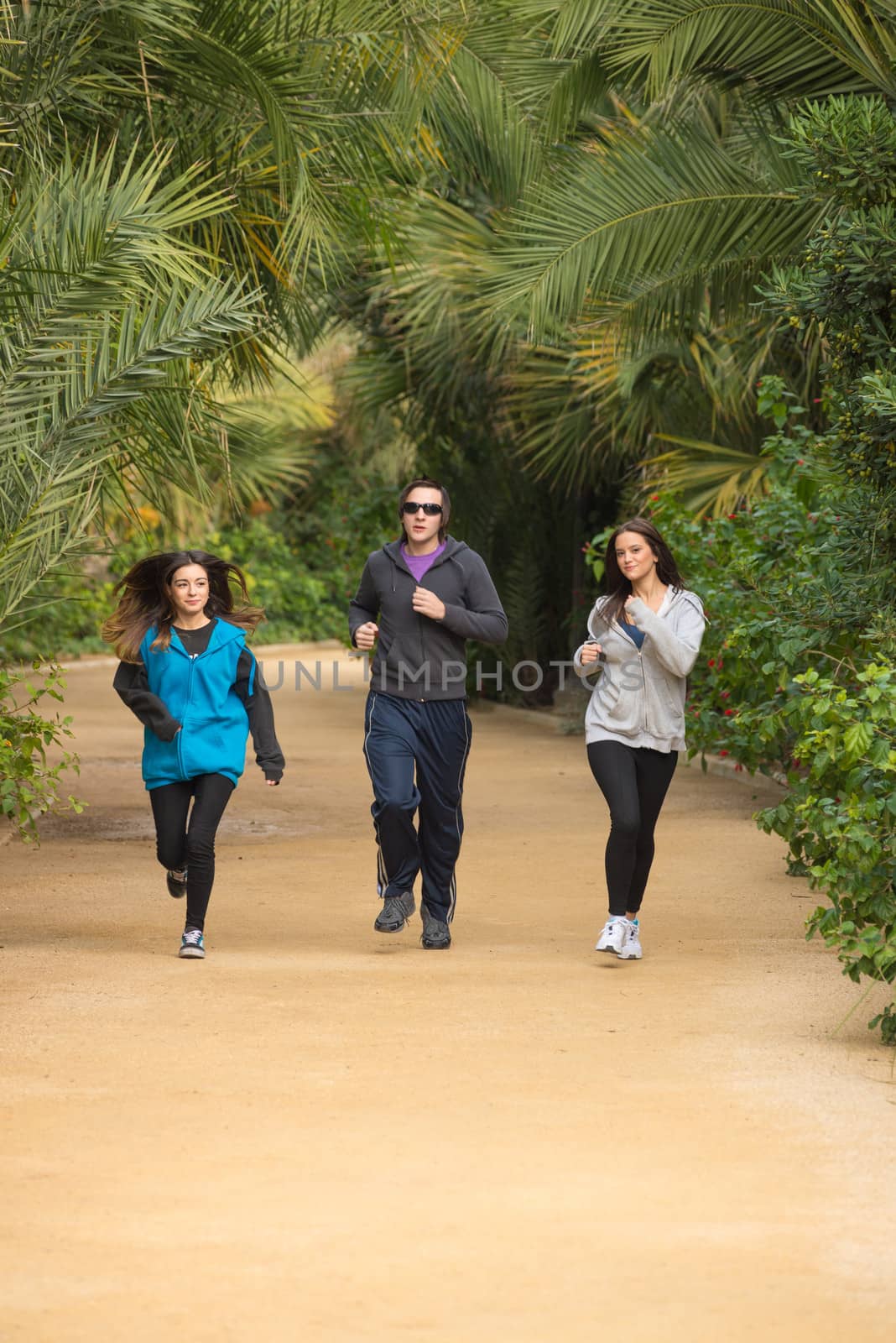 Active people jogging in a  lush park