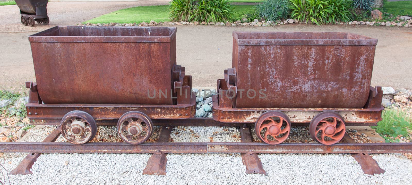 Rusted old mining carriages filled with stones by michaklootwijk