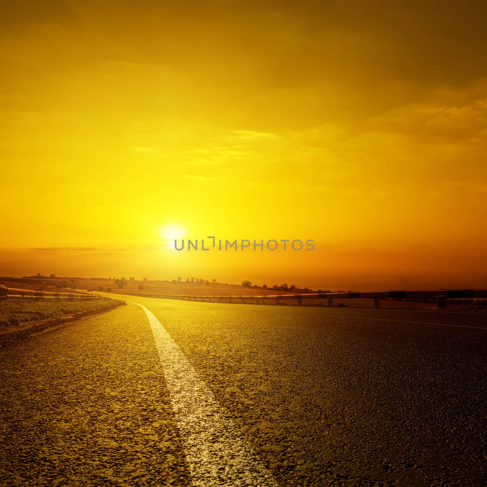 asphalt road and orange sunset by mycola