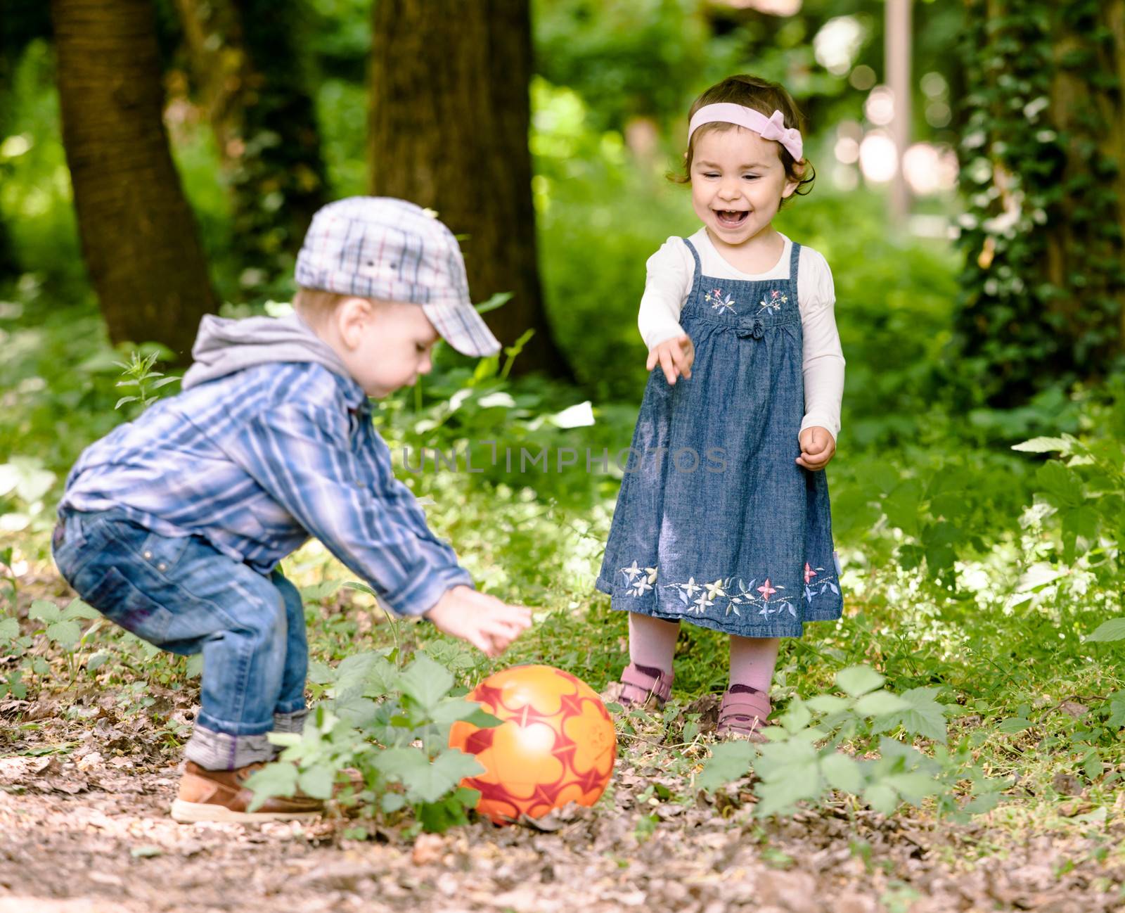 Boy and girl are playing with ball outdoor