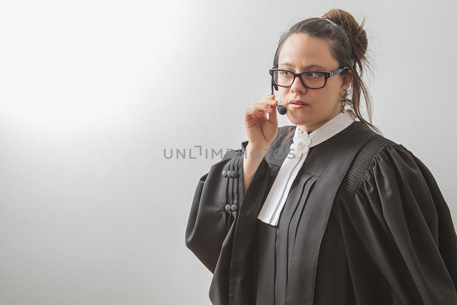thirty something brunette woman wearing a canadian lawyer toga with a telephone headset on her head