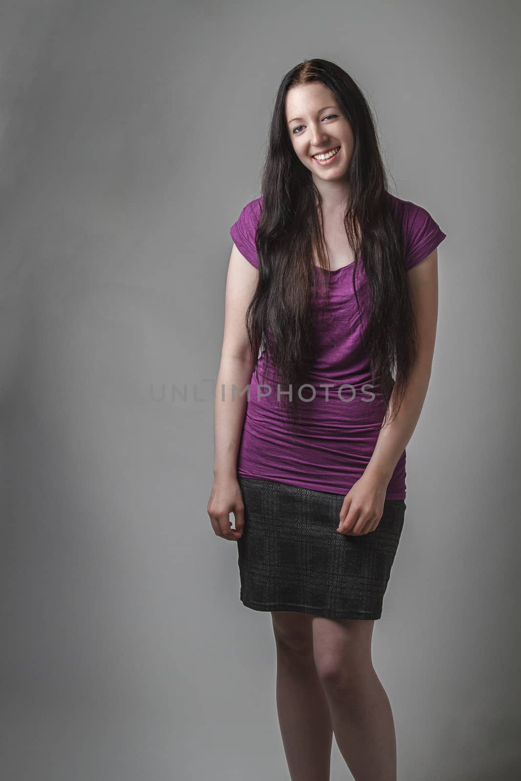 young woman with long black hair and a purple shirt and a great smile