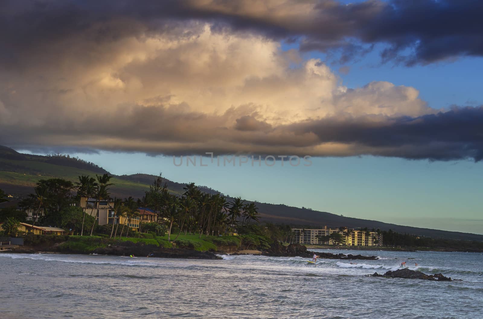 Surfer on Maui South shore at sunset