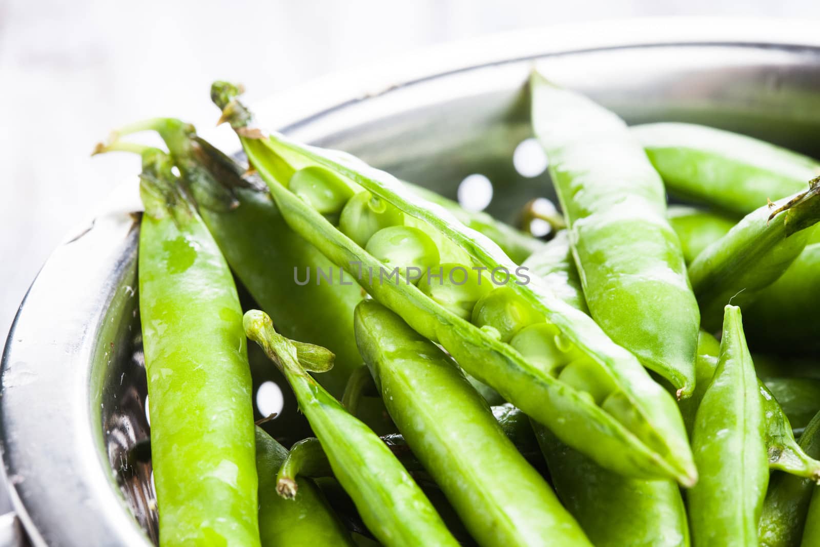 Green pea in the colander, close up