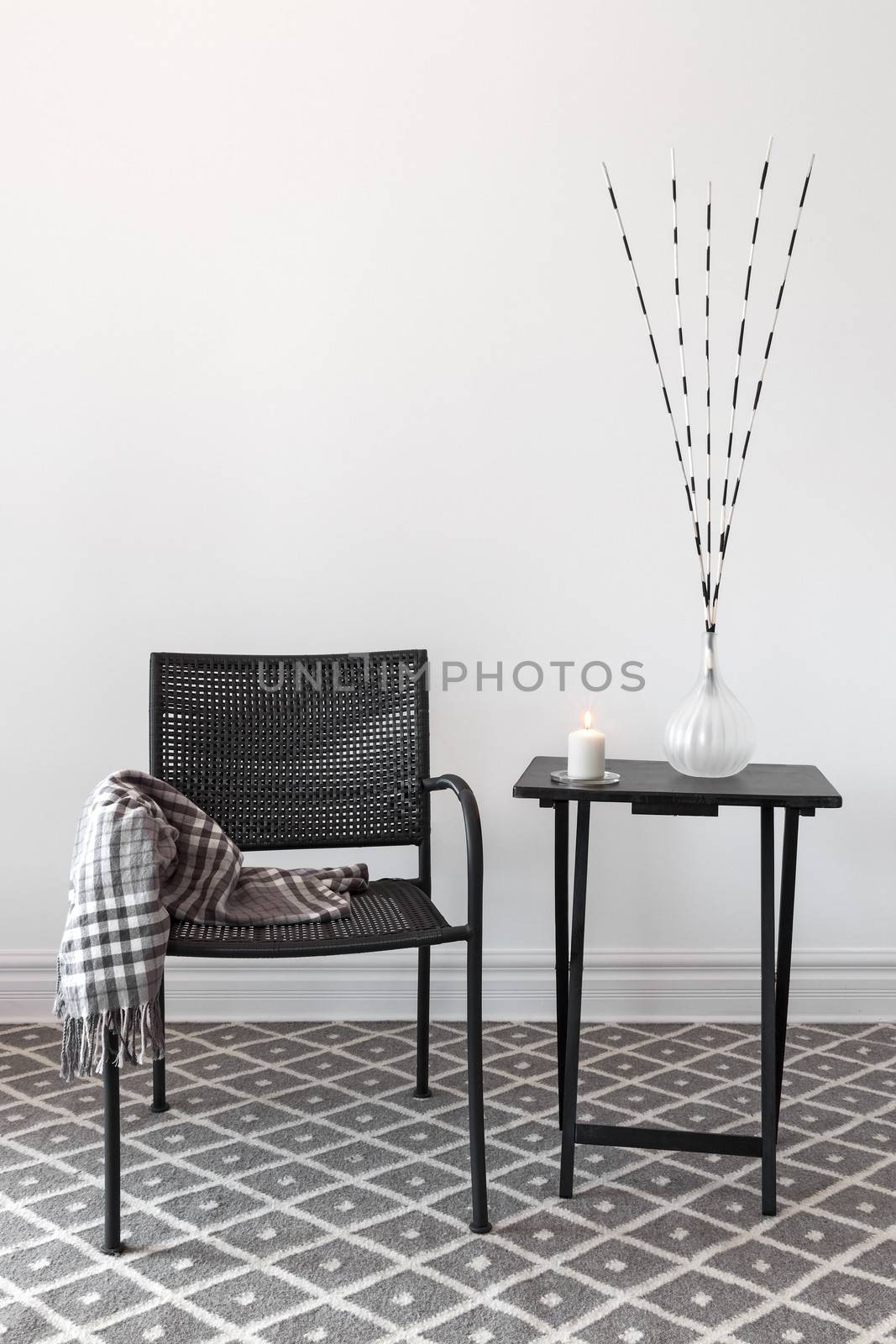 Home decor. Black armchair and little table decorated with decorations.